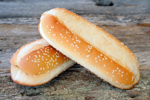 Two plain sub buns on an old piece of wood for the background.