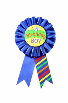 A blue ribbon for the Birthday Boy isolated on a white background.