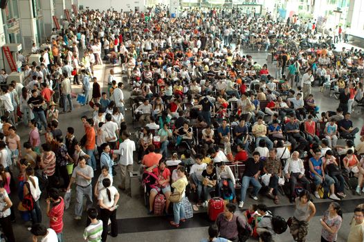 CHINA, SHUNDE TOWN, GUANGDONG PROVINCE - MARCH 10, 2006: crowd of Chinese people waiting at bus station.