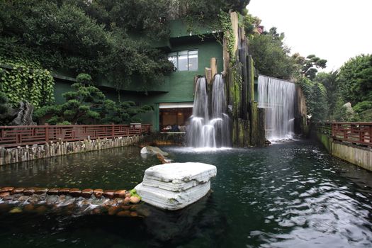 a chinese restaurant with waterfall outside