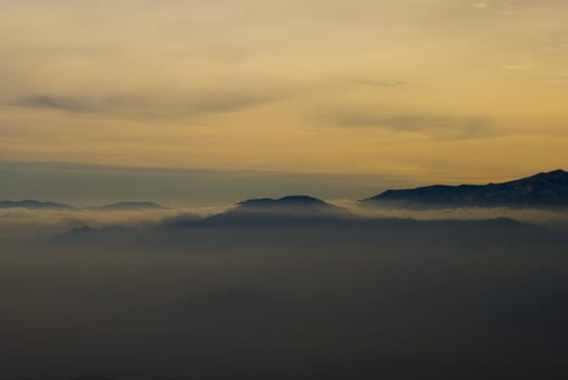 Mountain rises above thick fog