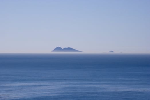Island rises above a foggy horizon