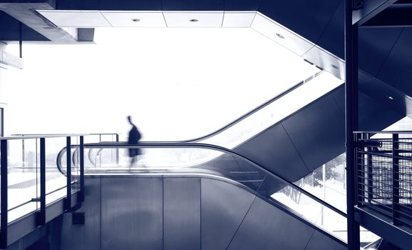 business man move on escalator, blue tone