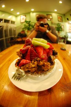 Person photographing a fruit tart