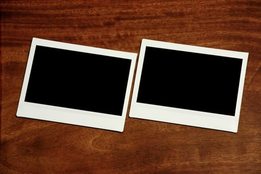 two empty polaroids on wooden background