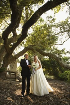 Mid-adult bride and groom standing outside of church.