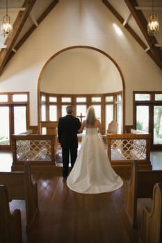 Portrait of bride and groom at alter of a church.