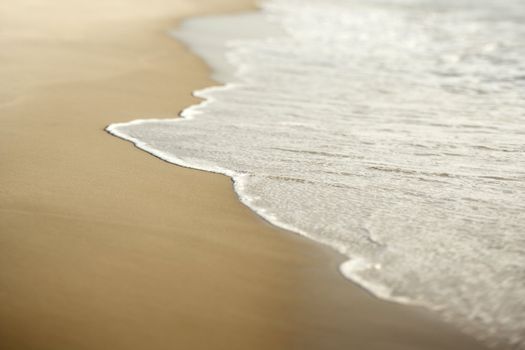 Image of sandy beach with waves.