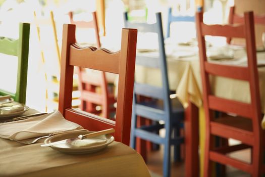 Different colored chairs at tables set for dining in Lisbon, Portugal.