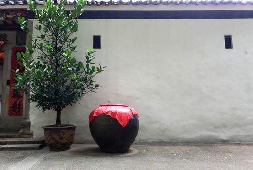 Asian style ceramic pot in frount of the white wall