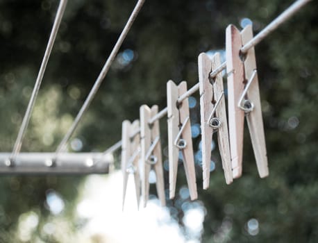 Shallow depth of field, several clothespins on the line outside.