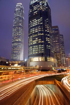 Night view of IFC (International Financial Centre) in Hong Kong with curving traffic light track.