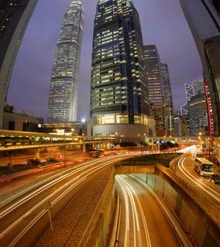 Night Fisheye view of IFC (International Financial Centre) in Hong Kong with curving traffic light track.