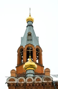Golden domes of the church and bell tower against the sky.