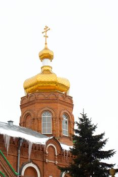 Golden dome of the church and the church building on the skyline.
