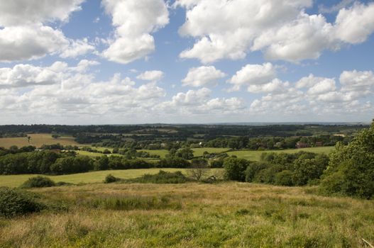 A view of the countryside in summer with a cloudy sky