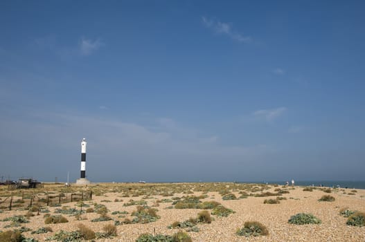 The pebble beach at Dungeness with the new lighthouse in the distance