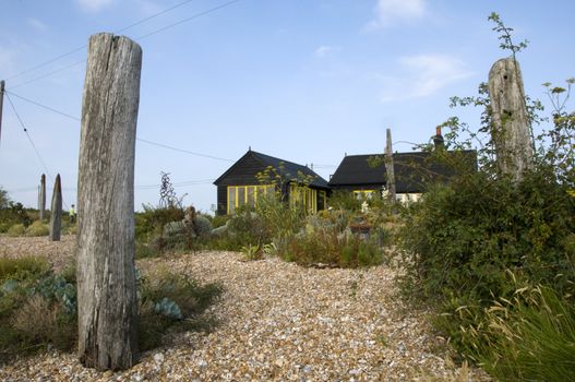 A wooden house on the beach with a post in the forground