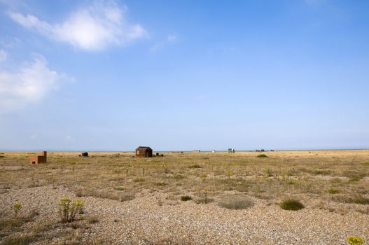 The beach at Dungeness with some huts in the distance