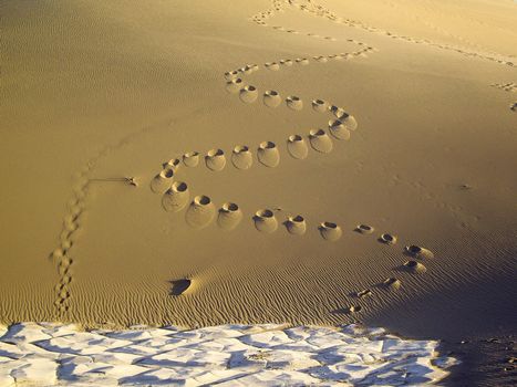 Footprints on steep slope of a dune in Death Valley USA
