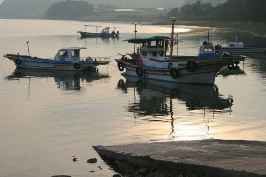 boats tied up to the wharf at taehan city korea in sunset