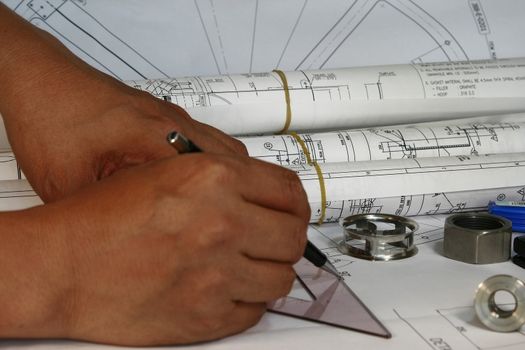 draftsman design his drafting works with parts and rolled drawings 