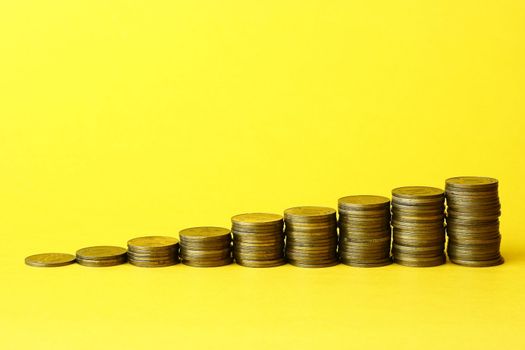 Coins Stack with yellow background close up
