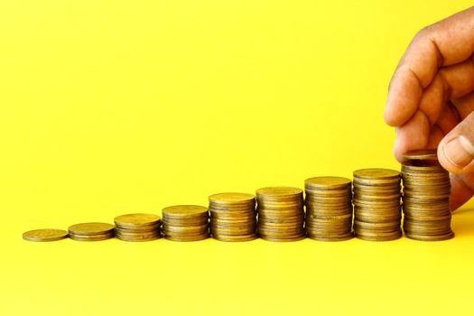 Gold coins stack in yellow background- investment is growing concept many uses for business