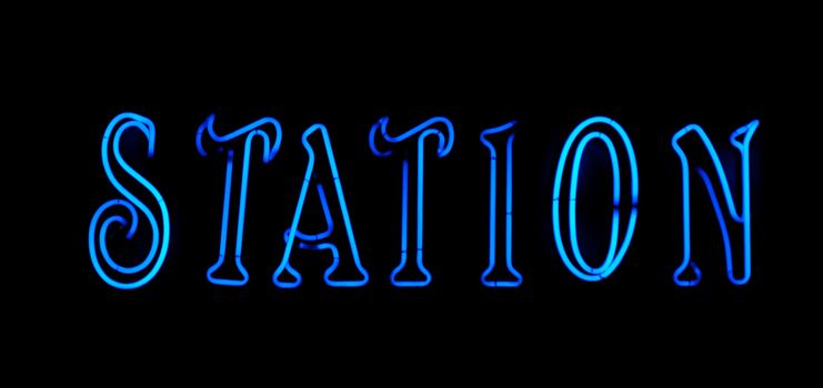 Blue station neon sign on black background