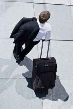 Corporate Man With Rolling Luggage Holding His Jacket
