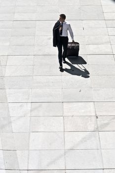 Young Corporate Man With Luggage Walking On Pavement