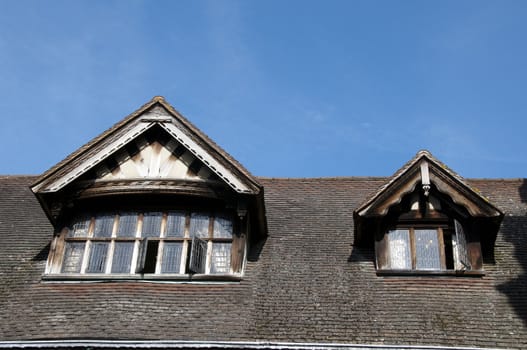 Detail of two Tudor windows with a blue sky