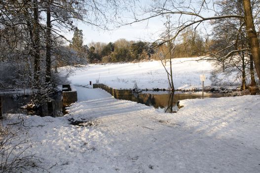 A footpath over a bridge  covered in snow