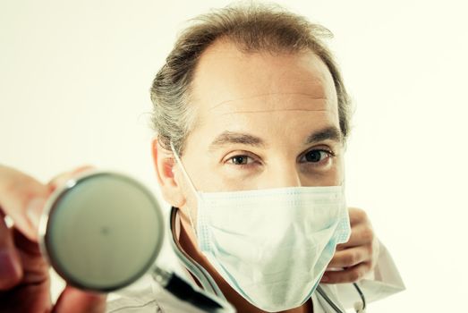 Doctor with stethoscope and flu mask.
