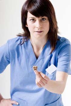 Veterinarian female shows a dog biscuit, focused on biscuit