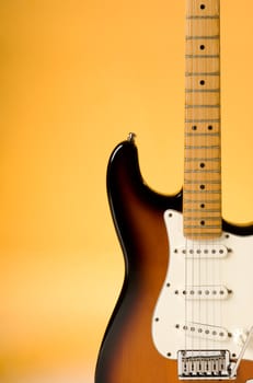 Electric guitar detail with orange lighting. 