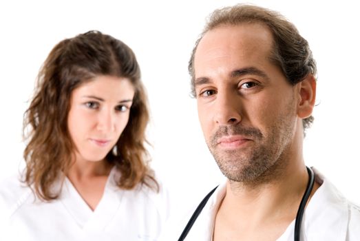 Adult doctor and young nurse on white background. Focused on doctor. 