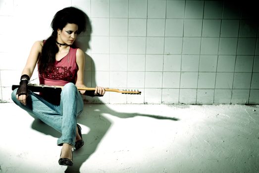 Punk Girl playing guitar on an "underground" background high contrast