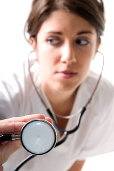 Young woman doctor with stethoscope on white background. Focused on stethoscope
