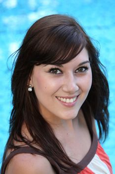 Beautiful brunette girl relaxing next to the swimming pool