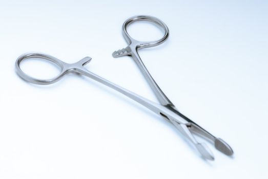 Surgical clamps on a soft blue background "surgical blue"