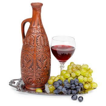Still life - a clay jug and a glass of red wine grape
