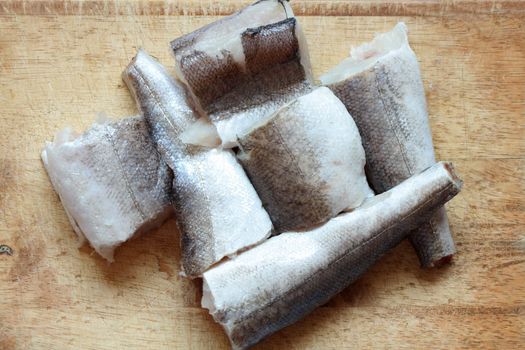 Closeup of sliced raw fish lying on wooden background