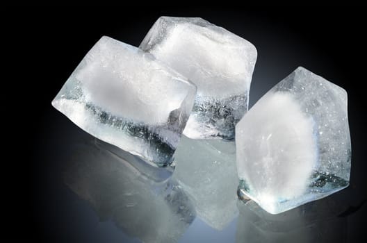 Three ice cubes isolated on dark background with clipping path