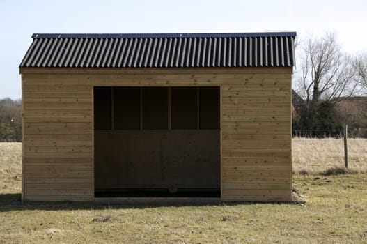 A wooden shed in field of grass