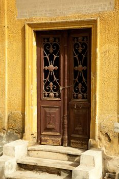Yellow wall and old door on Coptic Christian building in Cairo, Egypt