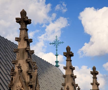 View over roof of cathedral towards wrought iron cross
