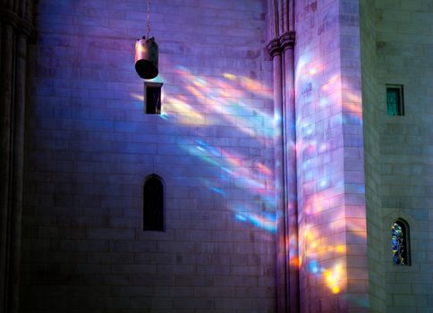 Light from stained glass windows falls on carved stonework in cathedral