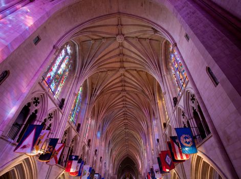 Light from stained glass windows falls on carved stonework in cathedral