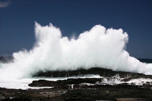 Wave exploding off rocks on the South African coast line
